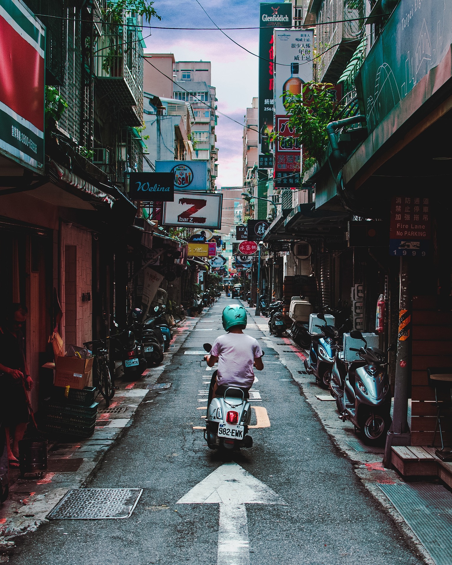 Man on moped in crowded alley